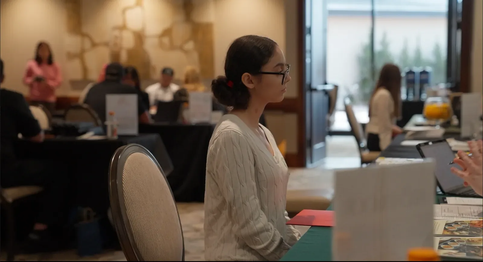 A student waits at a partner table during Draft Day interviews.